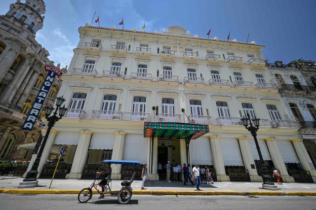 A pedicab rides past the Inglaterra Hotel, of the Canadian hotel chain Blue Diamond, in Havana, on June 1, 2026. The Canadian hotel group Blue Diamond Resorts said on june 1, 2026 it has shut down its operations in Cuba, dealing another blow to the country as it faces US President Donald Trump's takeover threats. (Photo by ADALBERTO ROQUE / AFP)