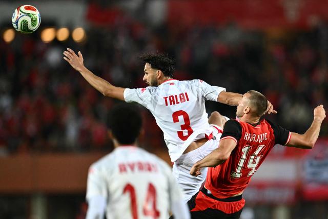 Tunisia's defender #03 Montassar Talbi (C) and Austria's forward #14 Sasa Kalajdzic (R) vie for the ball during the friendly football match between Austria and Tunisia in Vienna, Austria on June 1, 2026 ahead of the 2026 FIFA World Cup football tournament. (Photo by Joe Klamar / AFP)