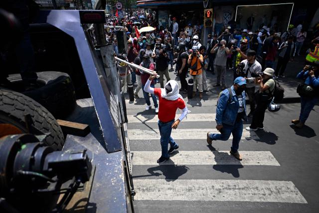 A protester hits a police crane during a protest by teachers ahead of the FIFA World Cup 2026, in Mexico City on June 1, 2026. (Photo by Alfredo ESTRELLA / AFP)