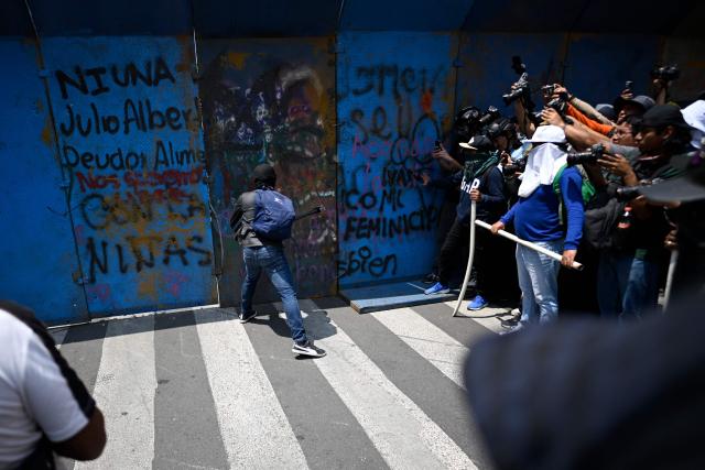 A demonstrator attempts to tear down a barricade blocking access to the Zocalo as teachers try to enter and set up a protest camp during a demonstration ahead of the 2026 FIFA World Cup, in Mexico City on June 1, 2026. (Photo by Alfredo ESTRELLA / AFP)