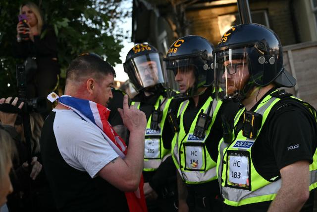 Demonstrators shouts at Police officers standing in riot gear near Portswood Police Station, following a protest march in Southampton, southern England, on June 2, 2026, held in reaction to the Police's handling of the detention of victim Henry Nowak, following the conviction of his murderer Vickrum Digwa. Body camera footage of dying student Henry Nowak, who was handcuffed by British police after being stabbed by Sikh man Vickrum Digwa, and falsely accused of racially abusing his murderer sparked outrage Tuesday. (Photo by JUSTIN TALLIS / AFP)