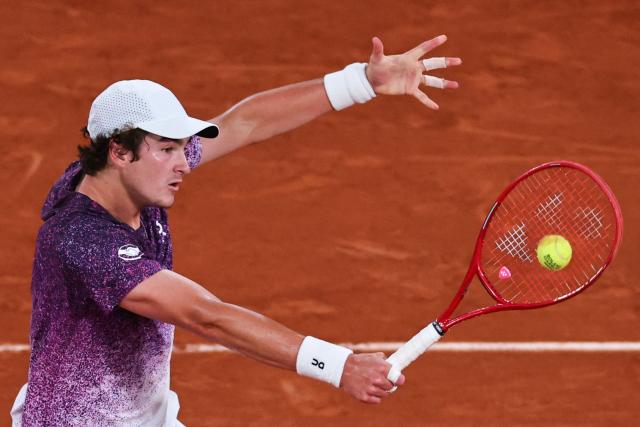 Brazil's Joao Fonseca plays a backhand return to Czech Republic's Jakub Mensik during their men's quarter final singles match on day 10 of the French Open tennis tournament on Court Philippe-Chatrier at the Roland-Garros Complex in Paris on June 2, 2026. (Photo by Anne-Christine POUJOULAT / AFP)