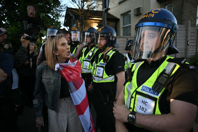 Demonstrators shouts at Police officers standing in riot gear near Portswood Police Station, following a protest march in Southampton, southern England, on June 2, 2026, held in reaction to the Police's handling of the detention of victim Henry Nowak, following the conviction of his murderer Vickrum Digwa. Body camera footage of dying student Henry Nowak, who was handcuffed by British police after being stabbed by Sikh man Vickrum Digwa, and falsely accused of racially abusing his murderer sparked outrage Tuesday. (Photo by JUSTIN TALLIS / AFP)