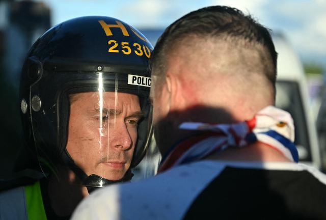 A demonstrator confronts a Police officer near Portswood Police station, following a protest march in Southampton, southern England, on June 2, 2026, held in reaction to the Police's handling of the detention of victim Henry Nowak, following the conviction of his murderer Vickrum Digwa. Body camera footage of dying student Henry Nowak, who was handcuffed by British police after being stabbed by Sikh man Vickrum Digwa, and falsely accused of racially abusing his murderer sparked outrage Tuesday. (Photo by JUSTIN TALLIS / AFP)