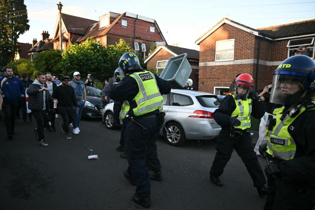 Police officers are attacked by demonstrators near Portswood Police Station, following a protest march in Southampton, southern England, on June 2, 2026, held in reaction to the Police's handling of the detention of victim Henry Nowak, following the conviction of his murderer Vickrum Digwa. Body camera footage of dying student Henry Nowak, who was handcuffed by British police after being stabbed by Sikh man Vickrum Digwa, and falsely accused of racially abusing his murderer sparked outrage Tuesday. (Photo by JUSTIN TALLIS / AFP)