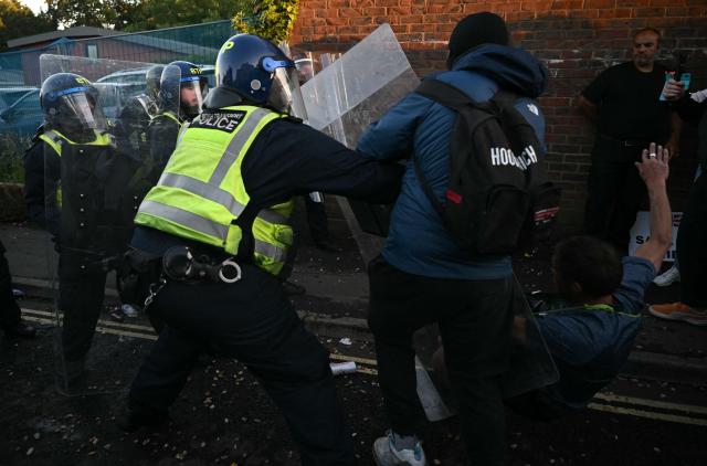 Police push back against a demonstrator after he kicked a police line near Portswood Police Station, following a protest march in Southampton, southern England, on June 2, 2026, held in reaction to the Police's handling of the detention of victim Henry Nowak, following the conviction of his murderer Vickrum Digwa. Body camera footage of dying student Henry Nowak, who was handcuffed by British police after being stabbed by Sikh man Vickrum Digwa, and falsely accused of racially abusing his murderer sparked outrage Tuesday. (Photo by JUSTIN TALLIS / AFP)
