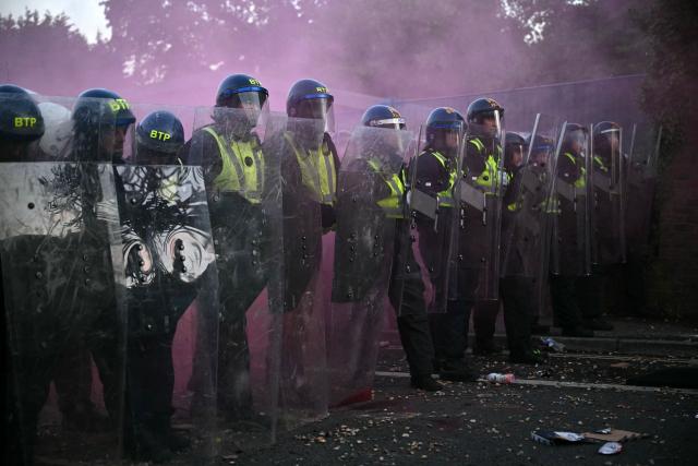Police officers in riot gear hold their line as near Portswood Police Station in Southampton, southern England, on June 2, 2026, during a protest held in reaction to the Police's handling of the detention of victim Henry Nowak, following the conviction of his murderer Vickrum Digwa. Body camera footage of dying student Henry Nowak, who was handcuffed by British police after being stabbed by Sikh man Vickrum Digwa, and falsely accused of racially abusing his murderer sparked outrage Tuesday. (Photo by JUSTIN TALLIS / AFP)