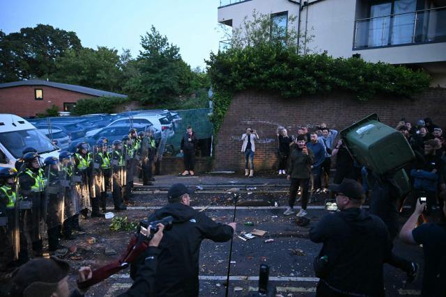A demonstrators throws a bin at police offices with wheelie pins near Portswood Police Station, following a protest march in Southampton, southern England, on June 2, 2026, during a protest held in reaction to the Police's handling of the detention of victim Henry Nowak, following the conviction of his murderer Vickrum Digwa. Body camera footage of dying student Henry Nowak, who was handcuffed by British police after being stabbed by Sikh man Vickrum Digwa, and falsely accused of racially abusing his murderer sparked outrage Tuesday. (Photo by JUSTIN TALLIS / AFP)