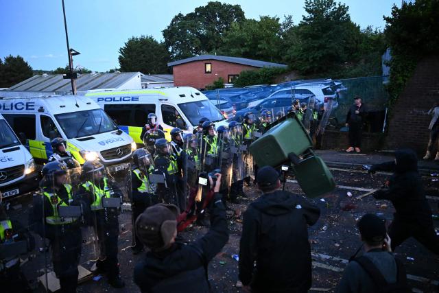 A demonstrator throws a bin at police offices with wheelie pins near Portswood Police Station in Southampton, southern England, on June 2, 2026, during a protest held in reaction to the Police's handling of the detention of victim Henry Nowak, following the conviction of his murderer Vickrum Digwa. Body camera footage of dying student Henry Nowak, who was handcuffed by British police after being stabbed by Sikh man Vickrum Digwa, and falsely accused of racially abusing his murderer sparked outrage Tuesday. (Photo by JUSTIN TALLIS / AFP)