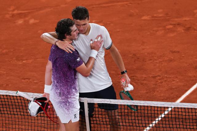 Winner Czech Republic's Jakub Mensik (R) greets Brazil's Joao Fonseca at the end of their men's quarter final singles match on day 10 of the French Open tennis tournament on Court Philippe-Chatrier at the Roland-Garros Complex in Paris on June 2, 2026. (Photo by Anne-Christine POUJOULAT / AFP)
