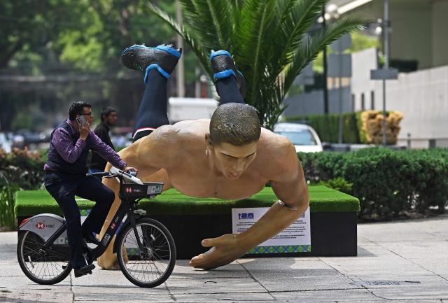 A man rides a bike past a giant sculpture alluding to the FIFA 2026 World Cup taken down during a protest by the National Coordination of Education Workers (CNTE) in Mexico City on June 2, 2026. Protesting teachers attacked an exhibition themed around the FIFA 2026 World Cup football tournament that had been set up on a famous avenue in Mexico City on June 2, 2026, in an effort to press their labour demands. (Photo by CARL DE SOUZA / AFP)