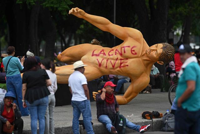 People gather around a giant sculpture alluding to the FIFA 2026 World Cup taken down during a protest by the National Coordination of Education Workers (CNTE) in Mexico City on June 2, 2026. Protesting teachers attacked an exhibition themed around the FIFA 2026 World Cup football tournament that had been set up on a famous avenue in Mexico City on June 2, 2026, in an effort to press their labour demands. (Photo by CARL DE SOUZA / AFP)