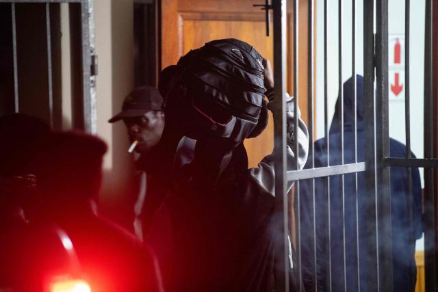 An immigrant carries his belongings into a community hall in Stanford, where they are taking refuge, in Stanford, about 120km from Cape Town, on June 2, 2026, after they were threatened in the communities in which they live. A rising tide in anti-immigrant sentiment, including protest marches and even violent attacks has been taking place in various places around South Africa. (Photo by RODGER BOSCH / AFP)