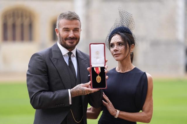 (FILES) Former England footballer David Beckham (L) poses next to his wife singer and fashion designer Victoria Beckham (R) with his medal after being appointed as a Knight Bachelor (Knighthood) for services to sport and charity at an investiture ceremony at Windsor Castle on November 4, 2025. Soccer star David Beckham will receive his star on the Hollywood Walk of Fame on June 12, one day after the start of the North American World Cup, the organization in charge of the famous boulevard reported on June 2. Tom Cruise and Victoria Beckham, “Posh Spice,” businesswoman and wife of the former British midfielder, will be the speakers at the ceremony honoring the former Manchester United and Real Madrid player. (Photo by Andrew Matthews / POOL / AFP)