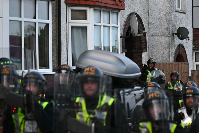 Police officers line a street around houses near Portswood Police Station in Southampton, southern England, on June 2, 2026, during a protest held in reaction to the Police's handling of the detention of victim Henry Nowak, following the conviction of his murderer Vickrum Digwa. Body camera footage of dying student Henry Nowak, who was handcuffed by British police after being stabbed by Sikh man Vickrum Digwa, and falsely accused of racially abusing his murderer sparked outrage Tuesday. (Photo by JUSTIN TALLIS / AFP)