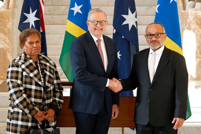 Solomon Islands Prime Minister Matthew Wale (R) shakes hands with Australia’s Prime Minister Anthony Albanese (C), next to Wale’s wife Veronica Ruala Waletofea, at Parliament House in Canberra on June 3, 2026. (Photo by Hilary Wardhaugh / AFP)