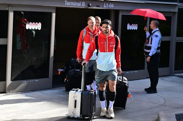 (L-R) Switzerland's football players Silvan Widmer, Miro Muheim and Eray Comert exit the terminal as team Switzerland arrives at Los Angeles International Airport (LAX) in Los Angeles, California on June 2, 2026 ahead of the FIFA World Cup. (Photo by Frederic J. Brown / AFP)