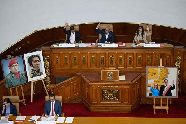 The president of Venezuela's National Assembly Jorge Rodriguez (C), first vice president Pedro Jose Infante (L) and second vice president Grecia Colmenares raise their hands during an ordinary session at the National Assembly in Caracas on June 2, 2026. Venezuela’s parliament began debating a reform that opens the door to private capital to help restore the state-controlled power system. (Photo by Federico PARRA / AFP)