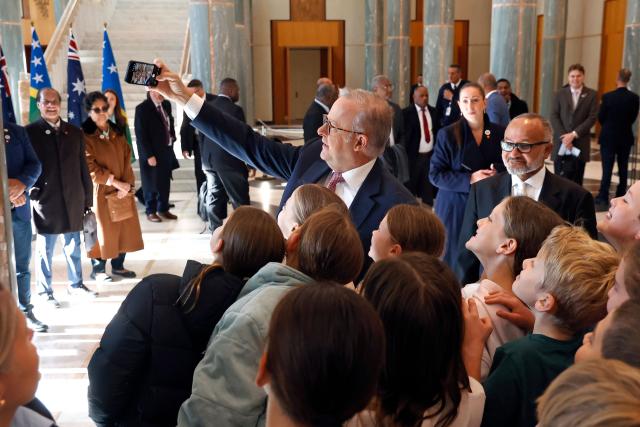 Solomon Islands Prime Minister Matthew Wale (R) watches as Australia’s Prime Minister Anthony Albanese (C) poses for a selfie with schoolchildren at Parliament House in Canberra on June 3, 2026. (Photo by Hilary Wardhaugh / AFP)