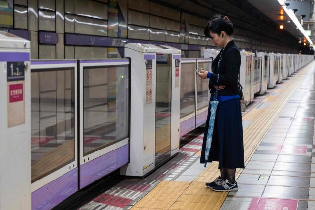 A woman holding her umbrella waits for a train on an empty platform at rush hour as severe tropical storm Jangmi passes over Tokyo on June 3, 2026. (Photo by ANDREW CABALLERO-REYNOLDS / AFP)