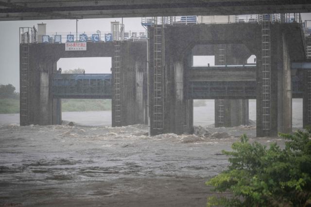 Water flows through sluice gates in the Tama river amid heavy rain brought by severe tropical storm Jangmi in Tokyo on June 3, 2026. (Photo by Yuichi YAMAZAKI / AFP)