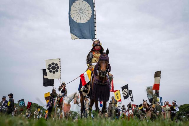 Horsemen clad in samurai armor attend a ceremony during the Soma Nomaoi festival at Hibarigahara field in Minamisoma, Fukushima prefecture on May 24, 2026. The Soma Nomaoi began as a way to train mounted warriors and it still looks the same a millennium later, with riders dressed in samurai armour battling it out in horseback events. (Photo by Yuichi YAMAZAKI / AFP) / To go with 'Japan-Climate-Festival-Tradition' Focus by Andrew MCKIRDY