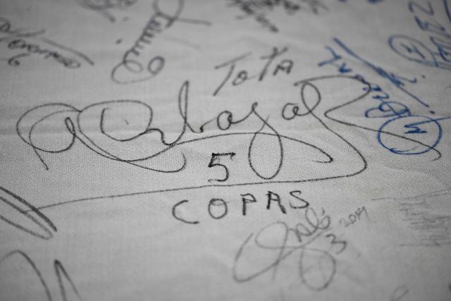 This image shows a detail of a national flag belonging to Mexican Alberto Obregon -inherited from his father, Fernando Obregon- signed by players of the national football team since the first FIFA World Cup held in Mexico in 1970 --date from which he has been collecting autographs-- at his home in Cuajimalpa, Mexico City, on June 2, 2026. Obregon recounts that the flag —which measures approximately five meters by three meters—has served as a reference point for collecting the history of the World Cups hosted in Mexico, as well as the Mexican national team's participation in other FIFA World Cups. (Photo by Yuri CORTEZ / AFP)