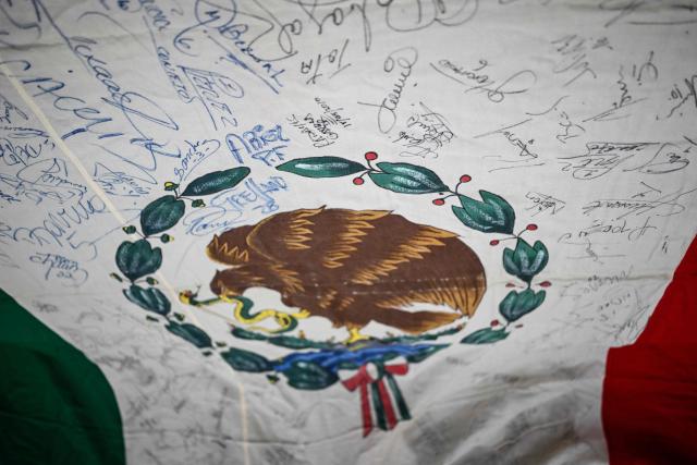 This image shows a detail of a national flag belonging to Mexican Alberto Obregon -inherited from his father, Fernando Obregon- signed by players of the national football team since the first FIFA World Cup held in Mexico in 1970 --date from which he has been collecting autographs-- at his home in Cuajimalpa, Mexico City, on June 2, 2026. Obregon recounts that the flag —which measures approximately five meters by three meters—has served as a reference point for collecting the history of the World Cups hosted in Mexico, as well as the Mexican national team's participation in other FIFA World Cups. (Photo by Yuri CORTEZ / AFP)