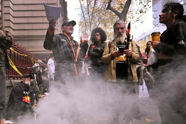 Aboriginal elder Djuran Bunjileenee Uncle Robbie Thorpe (L) speaks to supporters during a traditional smoking ceremony at the Victorian Supreme Court of Appeal in Melbourne on June 3, 2026. Thorpe appeared before the Victorian Supreme Court of Appeal seeking to charge Britain's King Charles III for the genocide of Aboriginal people. (Photo by William WEST / AFP)