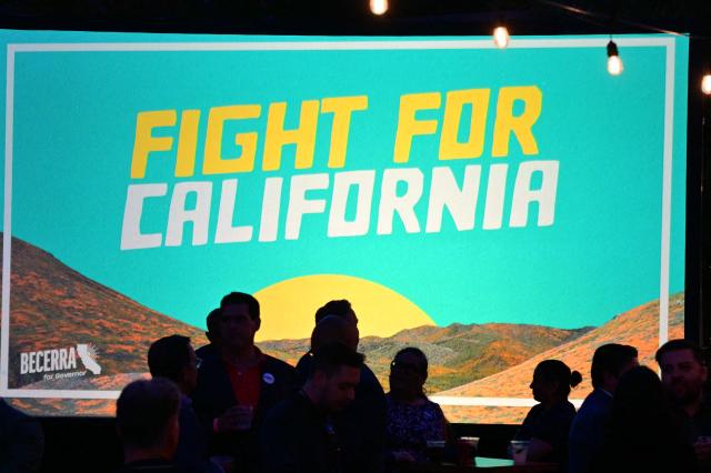 Supporters of Democrat California Gubernatorial candidate Xavier Becerra are seen silhouetted on a campaign sign during an election night event in downtown Los Angeles, on June 2, 2026. Californians went to the polls Tuesday in the first round of voting for a new governor, with a tight three-way race for two run-off spots, while people in Los Angeles will also be voting for a new mayor. The state's so-called "jungle primary" pits all comers against each other -- regardless of party -- with the top two vote-getters advancing to the November general election to replace term-limited Governor Gavin Newsom. (Photo by Frederic J. Brown / AFP)
