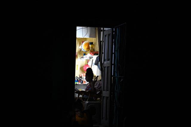 A woman checks a cell phone during a blackout in the Centro Habana neighbourhood in Havana on June 2, 2026. (Photo by ADALBERTO ROQUE / AFP)