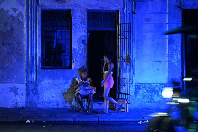 A woman checks a cell phone during a blackout in the Centro Habana neighbourhood in Havana on June 2, 2026. (Photo by ADALBERTO ROQUE / AFP)