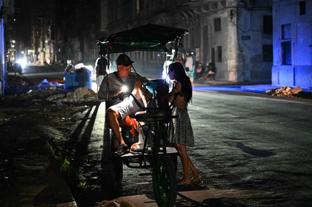 People gather on a bicycle taxi during a blackout in the Centro Habana neighbourhood in Havana on June 2, 2026. (Photo by ADALBERTO ROQUE / AFP)