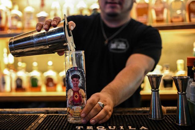 A bartender prepares a “Wemby” cocktail in a glass featuring an image of San Antonio Spurs French basketball player Victor Wembanyama, at a bar in downtown San Antonio, Texas, on June 2, 2026. The Spurs will face the New York Knicks in the NBA Finals, which begin on June 3. (Photo by RONALDO SCHEMIDT / AFP)