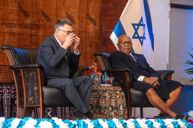 In this photo taken on June 2, 2026, Israeli Foreign Minister Gideon Sa'ar (L) sits with Fiji Prime Minister Sitiveni Rabuka (R) as he drinks a bowl of Kava during an official ceremony in Suva. (Photo by Leon Lord / AFP)