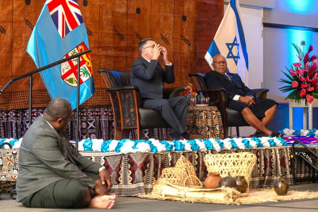 In this photo taken on June 2, 2026, Israeli Foreign Minister Gideon Sa'ar (C) sits with Fiji Prime Minister Sitiveni Rabuka (R) as he drinks a bowl of Kava during an official ceremony in Suva. (Photo by Leon Lord / AFP)