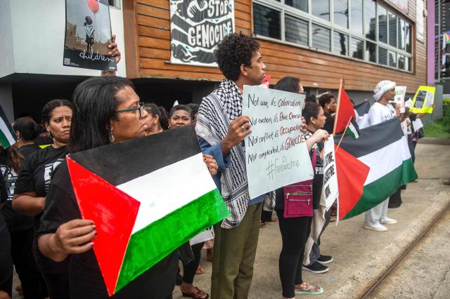 In this photo taken on June 2, 2026, pro-Palestinian supporters stand outside the new Israeli embassy in Suva as Israeli Foreign Minister Gideon Sa'ar and Fiji Prime Minister Sitiveni Rabuka attend a ceremony inside. (Photo by Leon Lord / AFP)