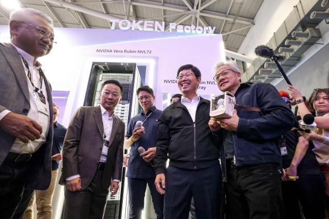Nvidia CEO Jensen Huang (2nd R) meets Foxconn CEO Young Liu (C-R) at the booth of Foxconn during Computex 2026 in Taipei on June 3, 2026. (Photo by I-Hwa Cheng / AFP)