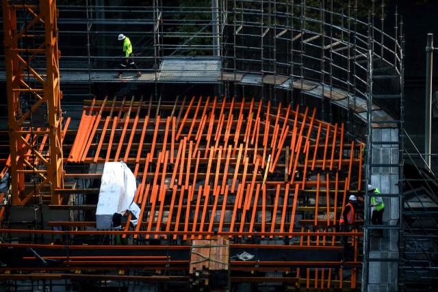 Construction workers walk and stand on scaffolding on a building site in the central business district (CBD) of Sydney on June 3, 2026. (Photo by DAVID GRAY / AFP)