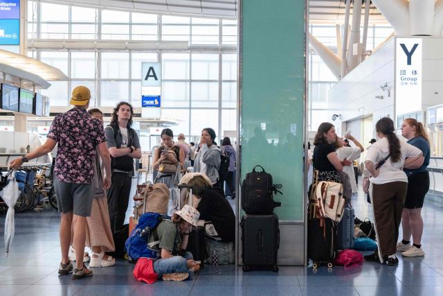 Passengers wait at the International Terminal at Haneda airport after flights were cancelled or severely delayed because of severe tropical storm Jangmi in Tokyo on June 3, 2026. A severe tropical storm moved towards Tokyo on June 3, with forecasters warning of floods after torrential rain battered swathes of the country and prompted calls to evacuate for hundreds of thousands of people. (Photo by Andrew CABALLERO-REYNOLDS / AFP)