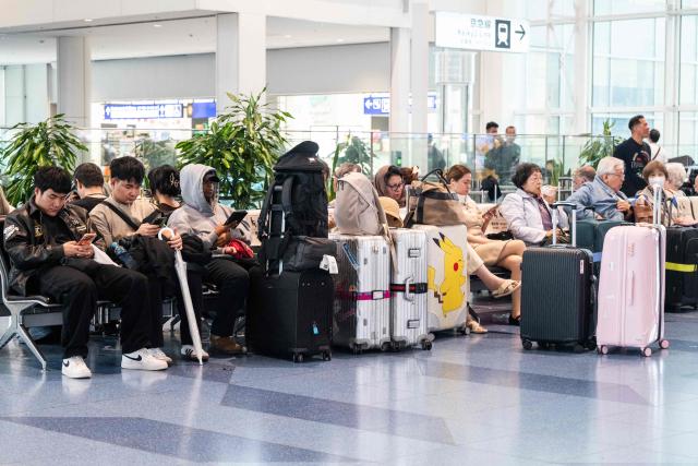 Passengers wait at the International Terminal at Haneda airport after flights were cancelled or severely delayed because of severe tropical storm Jangmi in Tokyo on June 3, 2026. A severe tropical storm moved towards Tokyo on June 3, with forecasters warning of floods after torrential rain battered swathes of the country and prompted calls to evacuate for hundreds of thousands of people. (Photo by Andrew CABALLERO-REYNOLDS / AFP)