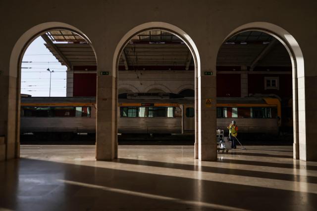 A worker cleans the platform as trains stand idle at Santa Apolonia train station during a nationwide general strike in Lisbon on June 3, 2026. Public transport and municipal services were severely disrupted in Portugal on Wednesday due to a 24-hour general strike over proposed labour reforms. The stoppage hit transport companies as well as waste collection, hospitals and schools, according to the General Confederation of Portuguese Workers (CGTP). (Photo by PATRICIA DE MELO MOREIRA / AFP)