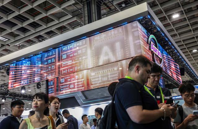 Visitors walk past a display featuring artificial intelligence and data centre imagery during Computex 2026 in Taipei on June 2, 2026. (Photo by I-Hwa Cheng / AFP)