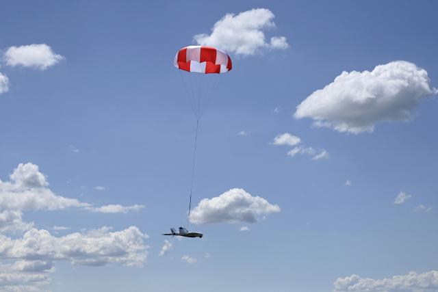 An UAV monitored by a serviceman of the State Border Guard Service of Ukraine lands with a parachute after a patrol flight along the Ukraine-Belarus border in Chernigiv region on June 1, 2026, amid the Russian invasion of Ukraine. (Photo by Genya SAVILOV / AFP)