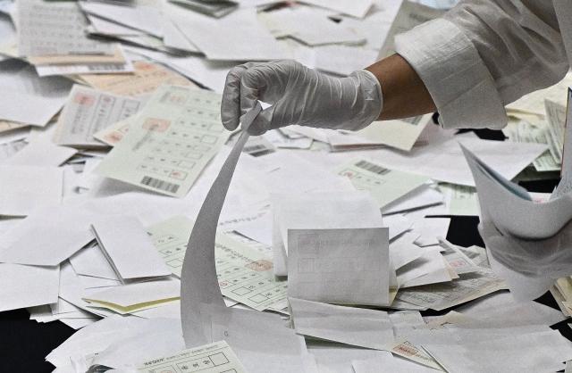 A election official sorts through ballots at a counting station for the local elections in Seoul on June 3, 2026. (Photo by Pedro Pardo / AFP)