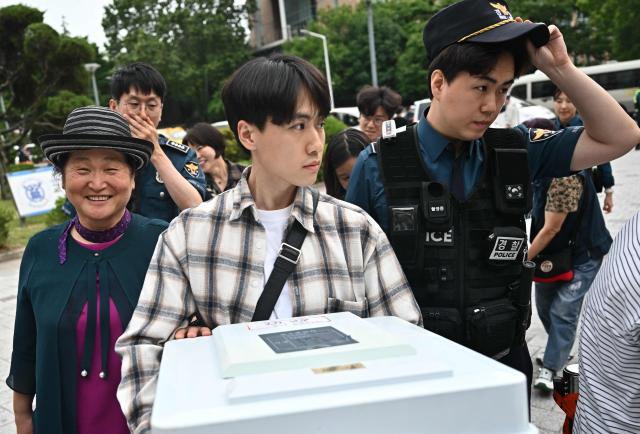 An election official carries a ballot box outside a counting station for the local elections in Seoul on June 3, 2026. (Photo by Pedro Pardo / AFP)