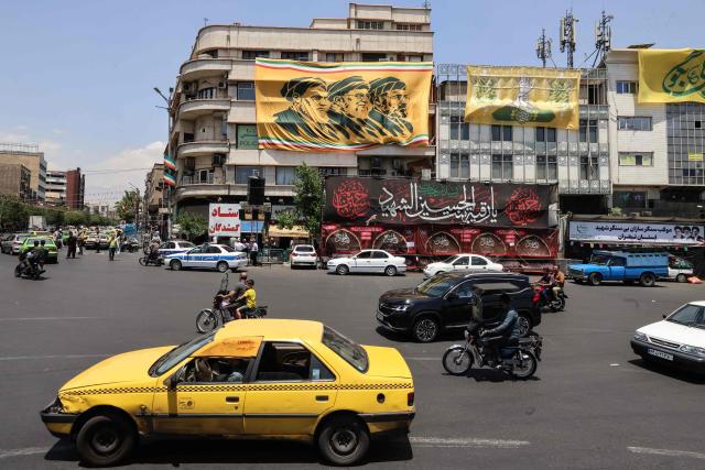Commuters drive past a banner depicting Iran's late supreme leader Ayatollah Ruhollah Khomeini (L), his successor, the late Ayatollah Ali Khamenei (C), and the new supreme leader Mojtaba Khamenei in Tehran on June 3, 2026. The military adviser to Iran's supreme leader on June 3, warned of more missile and drone strikes should the United States renew its attacks on Iran. The warning followed US strikes on an Iranian tanker and on Iran's Qeshm island, sparking retaliatory attacks on Kuwait and Bahrain. (Photo by ATTA KENARE / AFP) / 