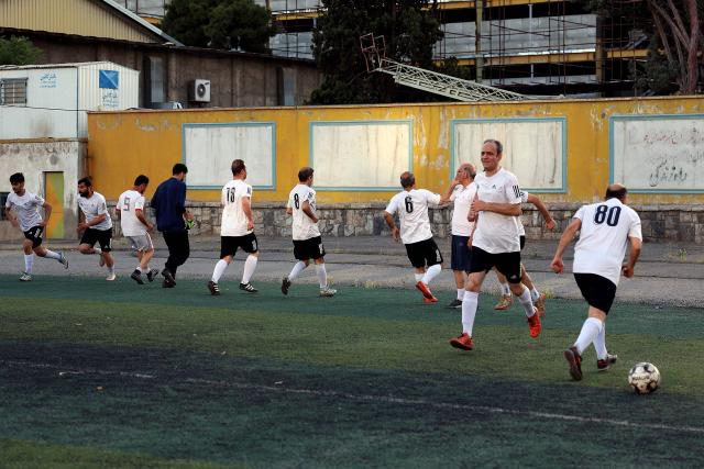 Iranian elderly and retired footballers warm up before a game in Tehran on May 8, 2026. Iran's national team, also known as TeamMelli, open their 2026 World Cup campaign, co-hosted by the United States, Mexico and Canada, against New Zealand in Los Angeles on June 15 before lining up against Belgium and Egypt in Group G. Iran has been at war with the United States and Israel since February 28, though a fragile ceasefire has been in place since April 8. Tehran and Washington have had no diplomatic relations since 1980 following the hostage crisis at the US embassy, which came after the Islamic revolution that toppled the US-backed shah. (Photo by AFP)