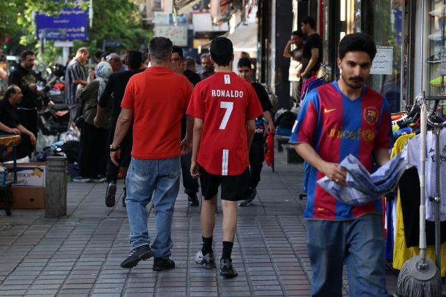 An Iranian youth wearing a football jersey of Portugal's forward Cristiano Ronaldo walks in Tehran on May 8, 2026. Iran's national team, also known as TeamMelli, open their 2026 World Cup campaign, co-hosted by the United States, Mexico and Canada, against New Zealand in Los Angeles on June 15 before lining up against Belgium and Egypt in Group G. Iran has been at war with the United States and Israel since February 28, though a fragile ceasefire has been in place since April 8. Tehran and Washington have had no diplomatic relations since 1980 following the hostage crisis at the US embassy, which came after the Islamic revolution that toppled the US-backed shah. (Photo by AFP)