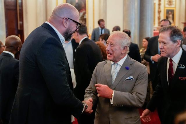 Britain's King Charles III (C) shakes hands with British comedian Tom Davis (L) as he hosts a Youth Opportunity Summit at a reception at Buckingham Palace in London on June 3, 2026. (Photo by Andrew Matthews / POOL / AFP)